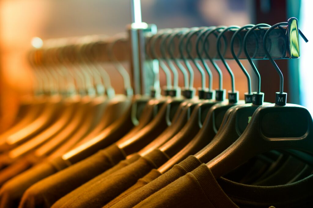 Close-up of hanging shirts on display with hangers in a clothing store